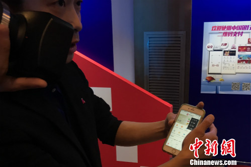 一位工作人员正在教体验者使用云闪付产品。<a target='_blank'  data-cke-saved-href='http://www.chinanews.com/' href='http://www.chinanews.com/' >中新网</a> 种卿 摄