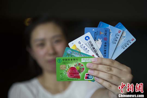 民众展示银行卡。 <a target='_blank'  data-cke-saved-href='http://www.chinanews.com/' href='http://www.chinanews.com/'>中新社</a>记者 张云 摄 