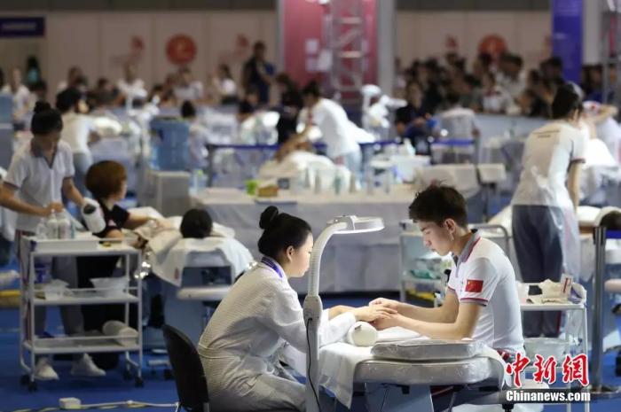 资料图:2018中国技能大赛现场,美容师正在给体验者做指甲。 张亨伟 摄 资料图:2018中国技能大赛现场,美容师正在给体验者做指甲。 张亨伟 摄
